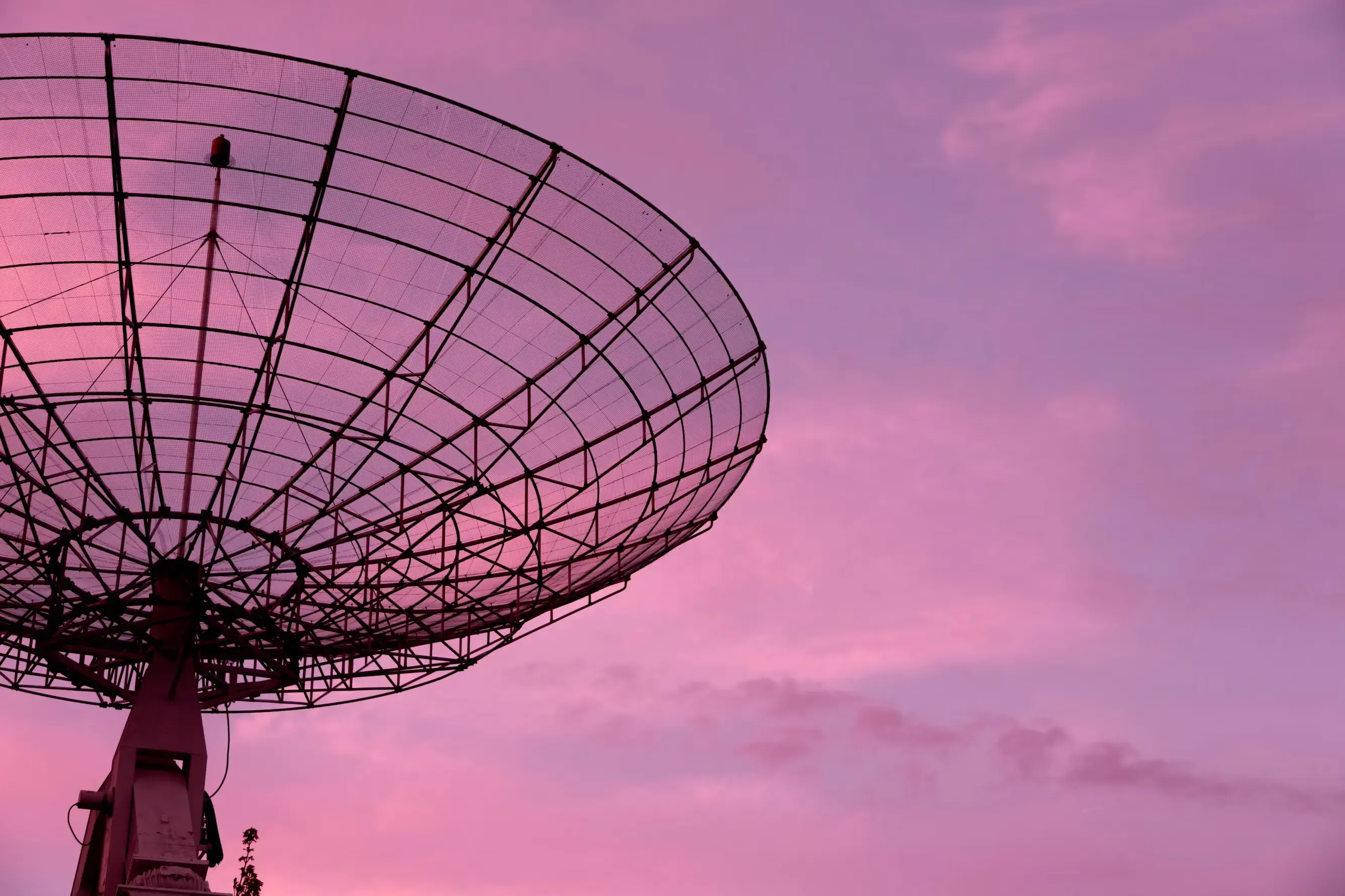 Black satellite under the pink sky.